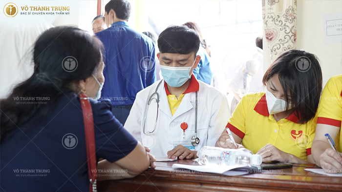 Một bác sĩ trong đoàn thiện nguyện kết nối nụ cười trái tim mùa 12 đang tiến hành lên toa thuốc cho một nữ bệnh nhân